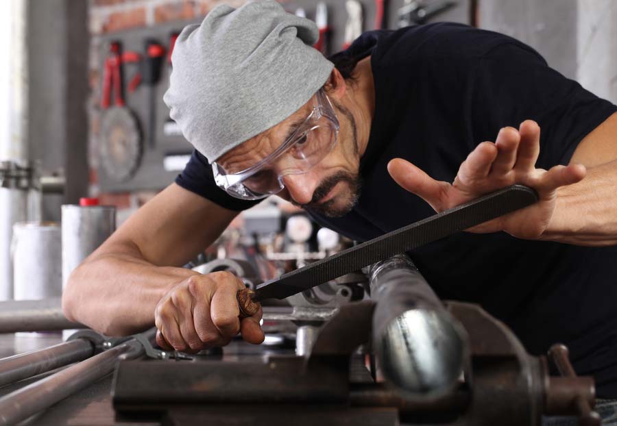 Người thợ cơ khí thao tác với dũa kim loại